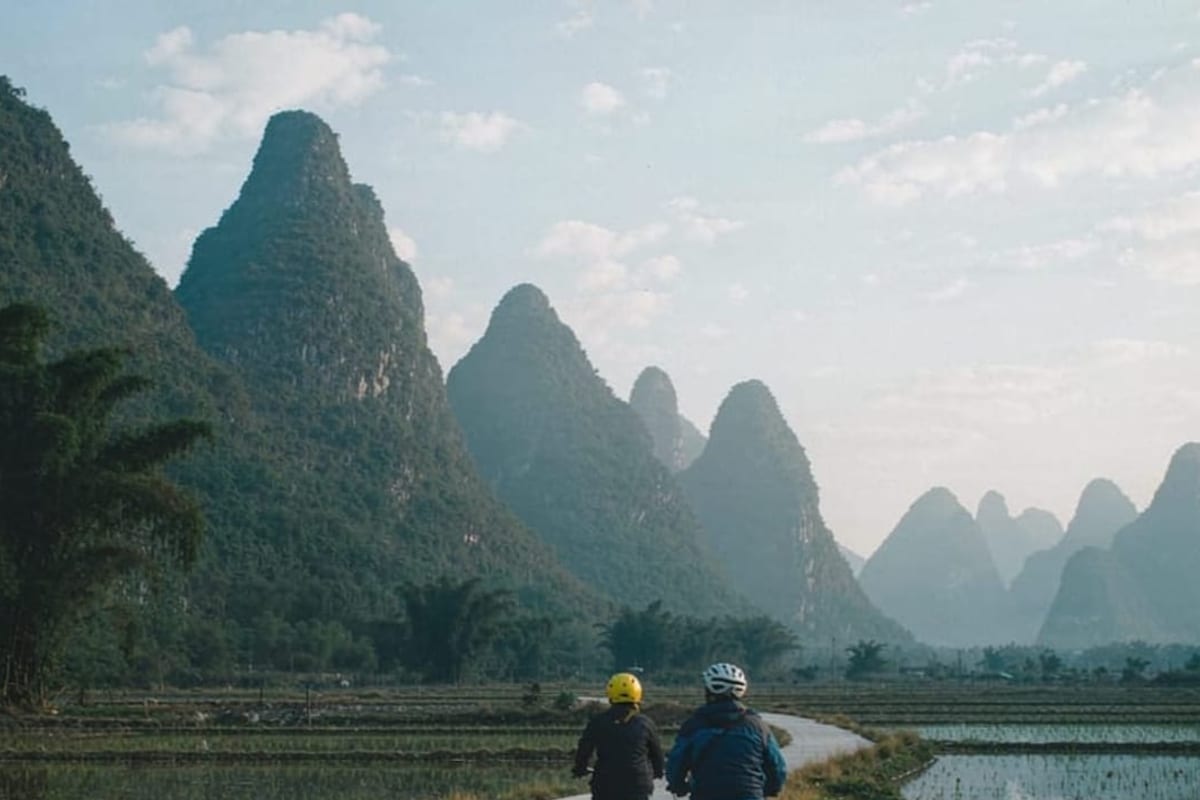Ciclistas entre arrozais alagados perto de Yangshuo