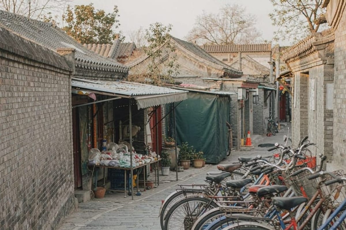 Rua de hutong em Pequim com bicicletas ao entardecer