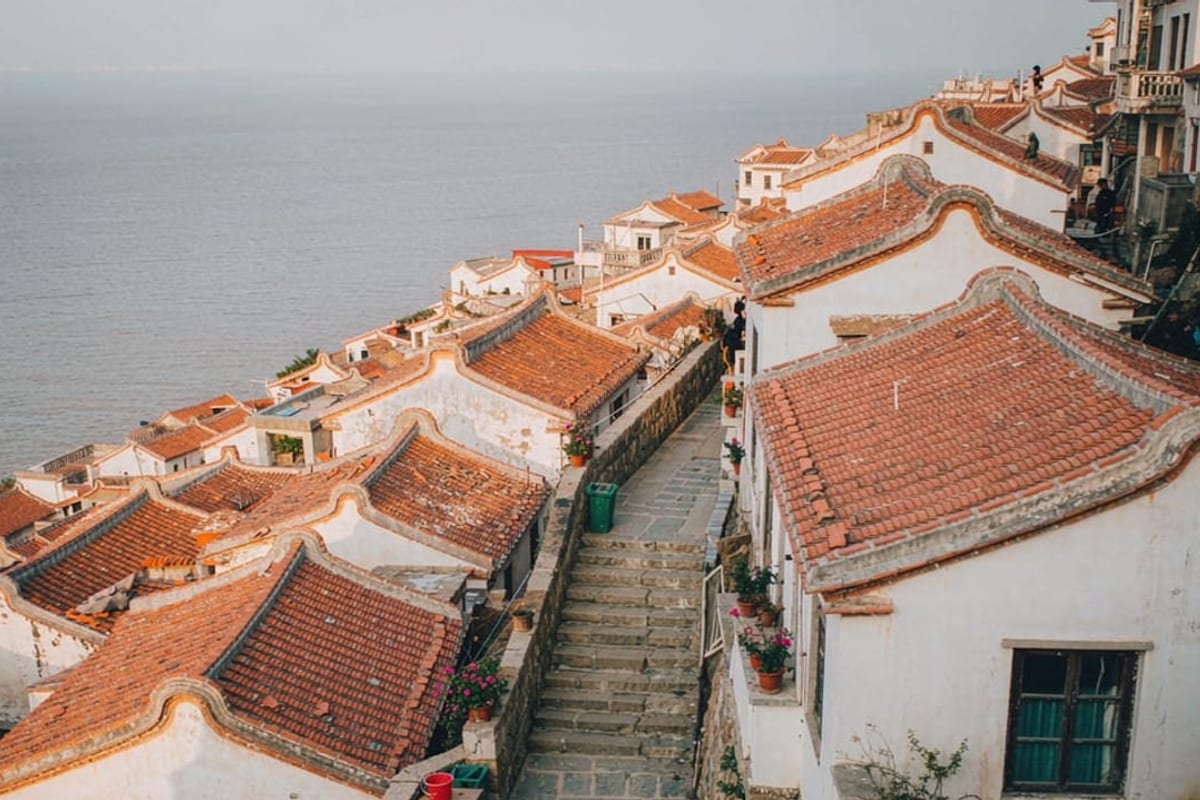 Casas de telhado vermelho e mar ao fundo em Qingdao