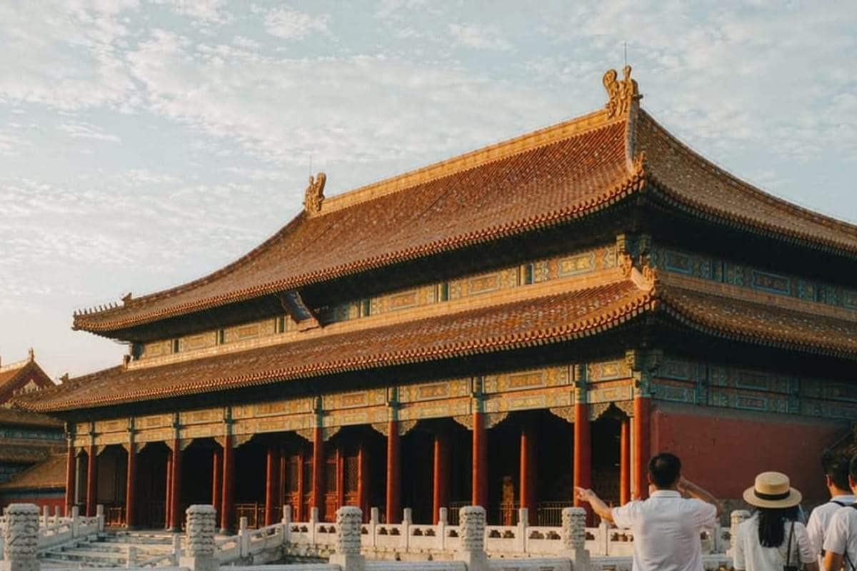 Viajantes com guia em pátio de palácio chinês