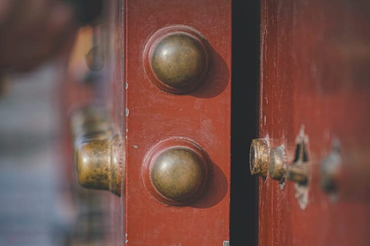 Portas vermelhas com cravos de bronze na Cidade Proibida