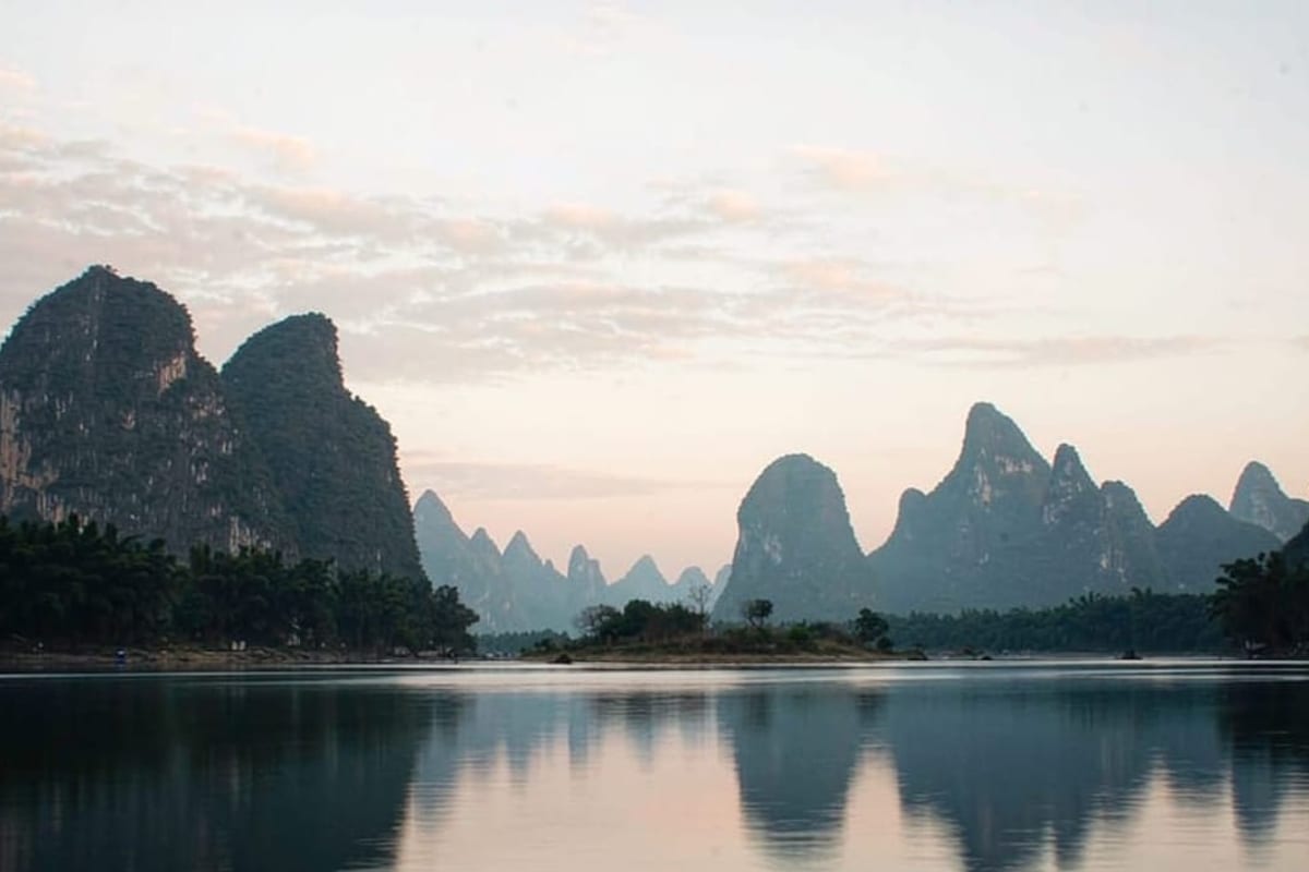 Picos calcários refletidos no rio Li ao amanhecer
