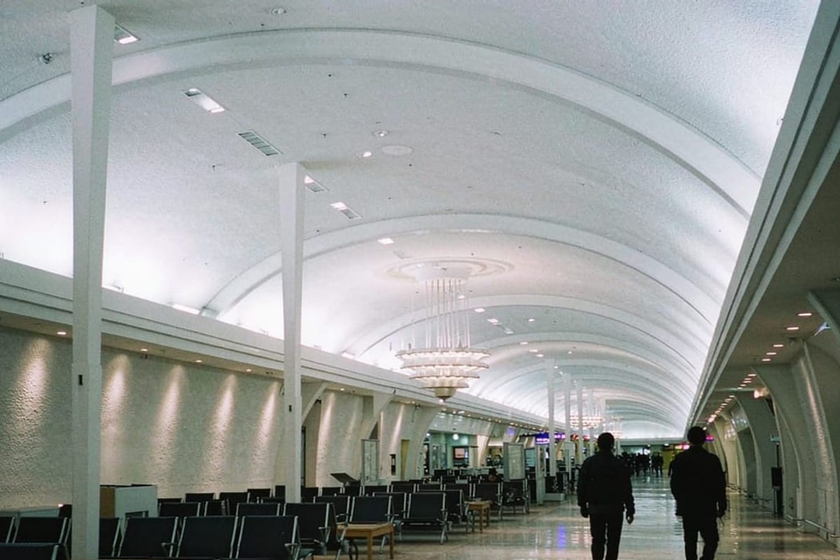 Saguão de aeroporto moderno com passageiros em trânsito