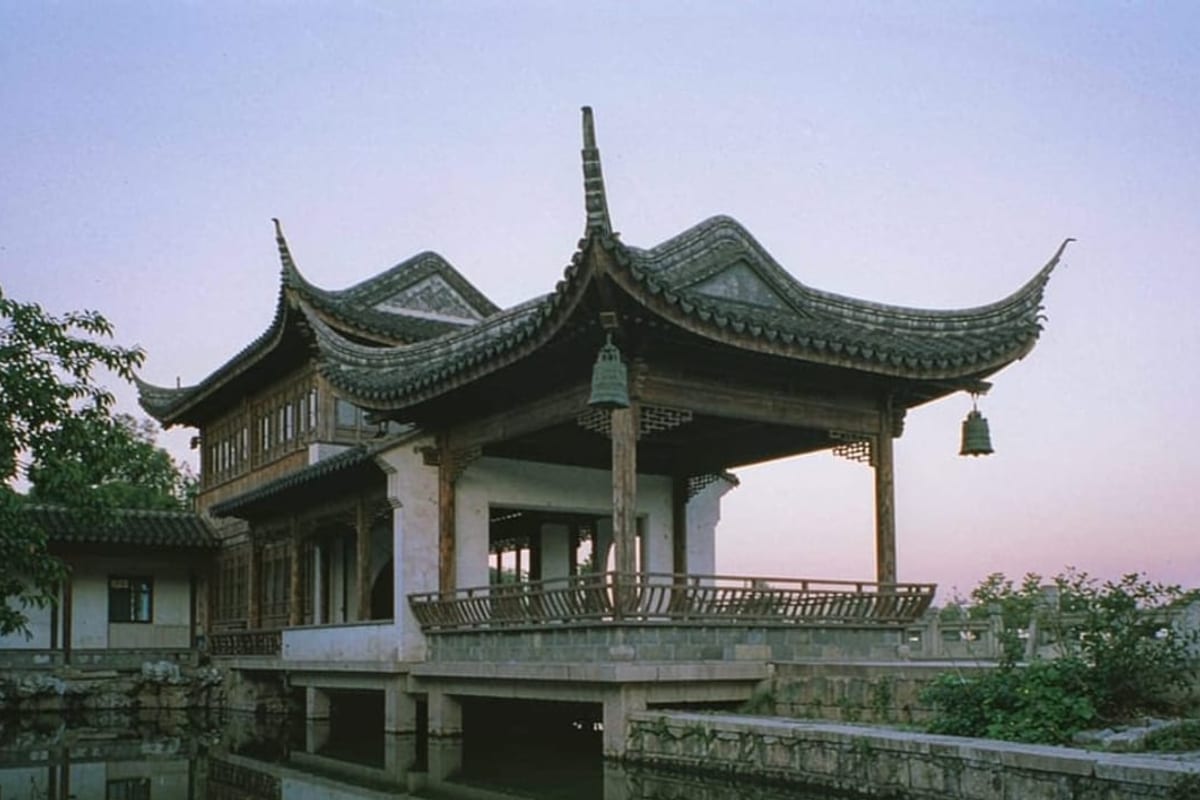 Pavilhão chinês refletido em lago ao entardecer